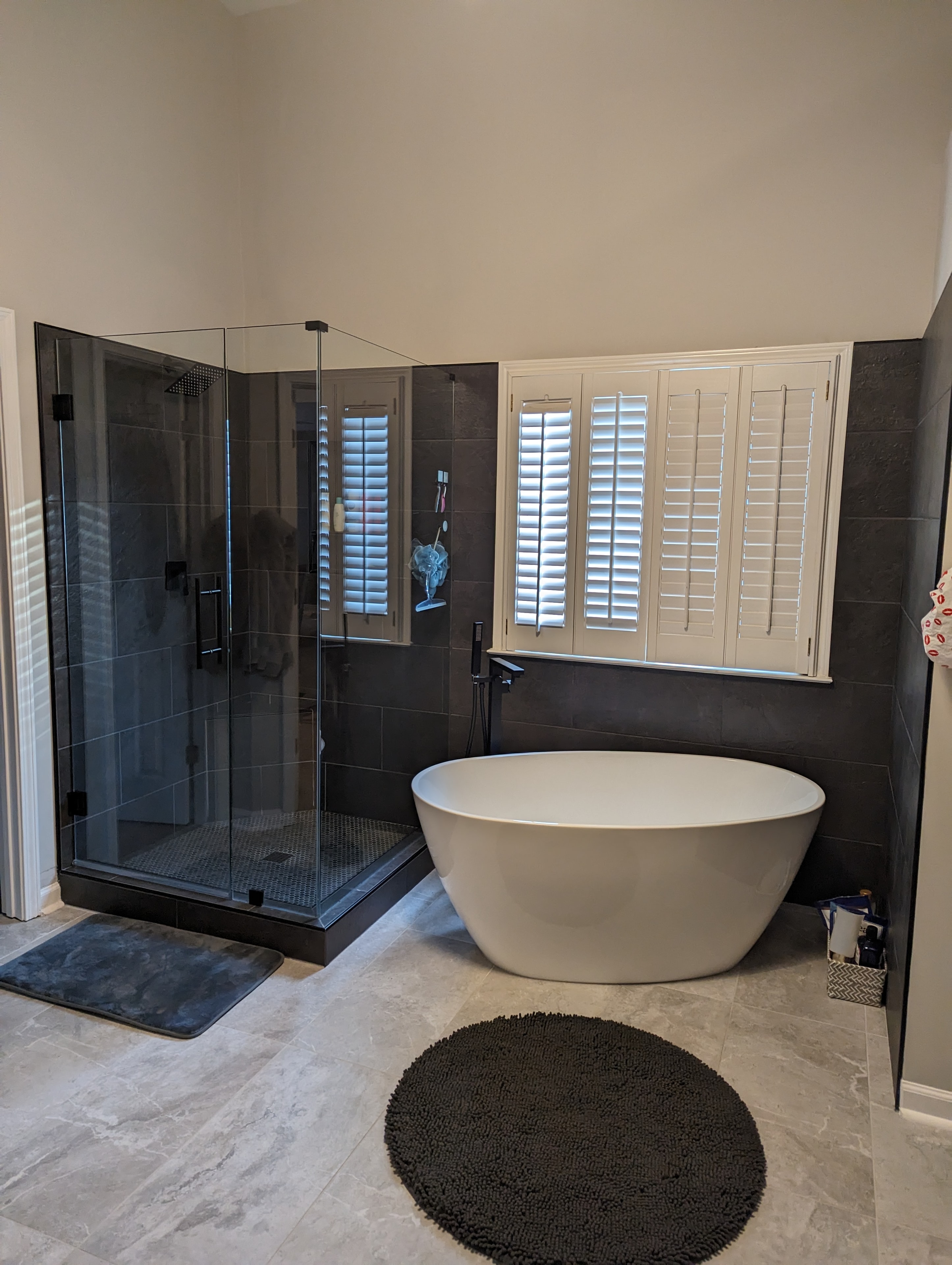 Bathroom renovation – freestanding soaking tub with glass shower enclosure and dark tile