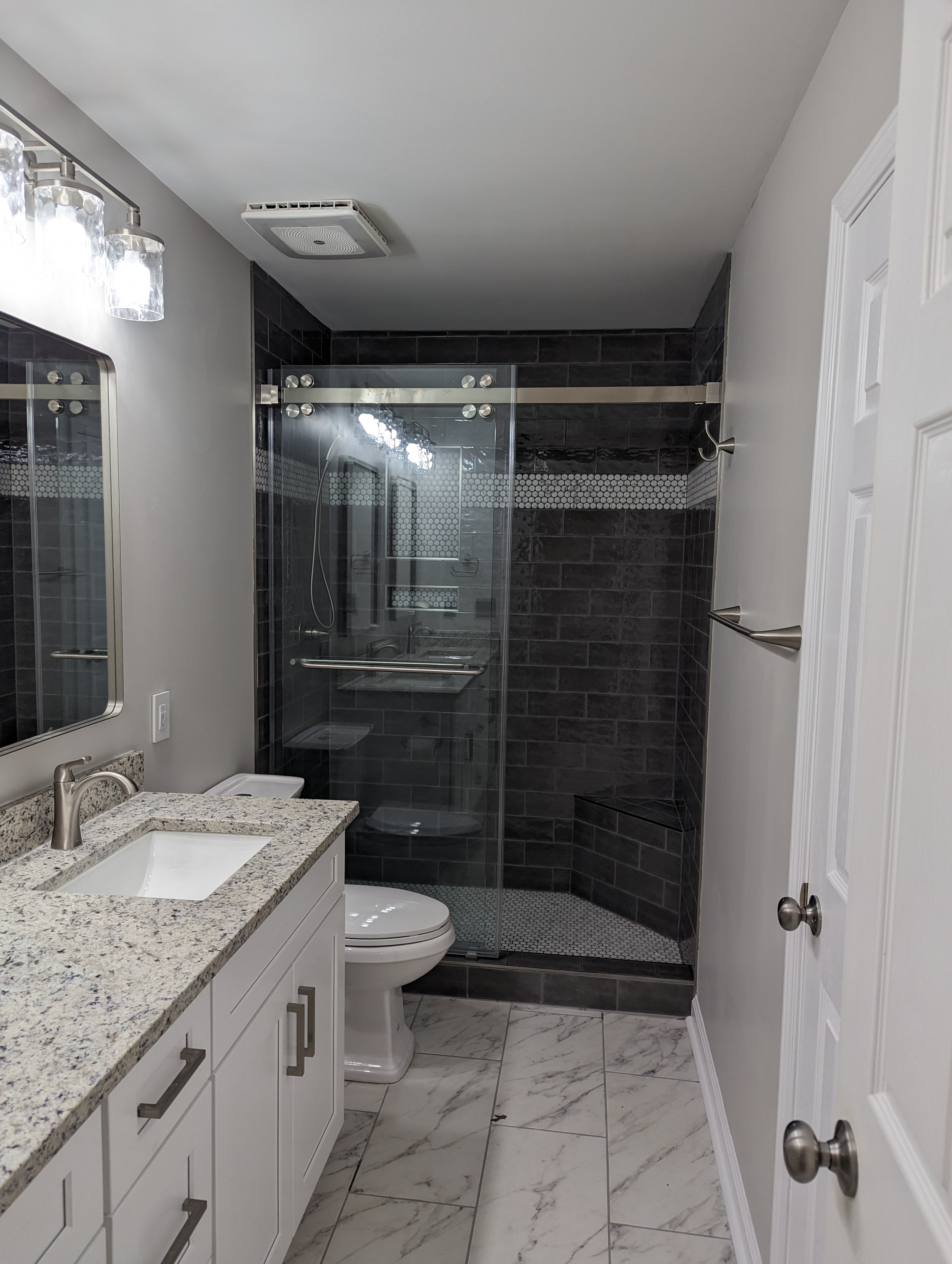 Harris bathroom renovation – dark tile walk-in shower with glass enclosure